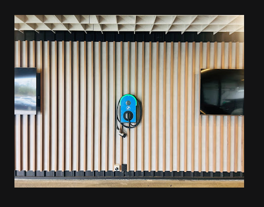 BMW wall-mounted EV charger installed by Hexar Solutions on timber slat feature wall at BMW Motorline Brisbane dealership